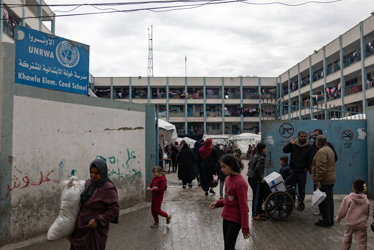 فلسطينيون.ات نازحون.ات داخلياً أمام مدرسة تديرها الأونروا في رفح، جنوب قطاع غزة.