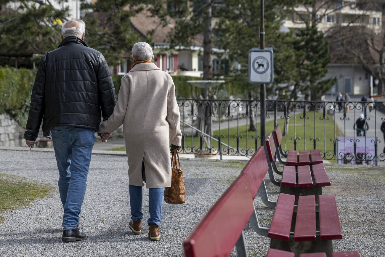 Ein älteres Paar läuft durch einen Park.
