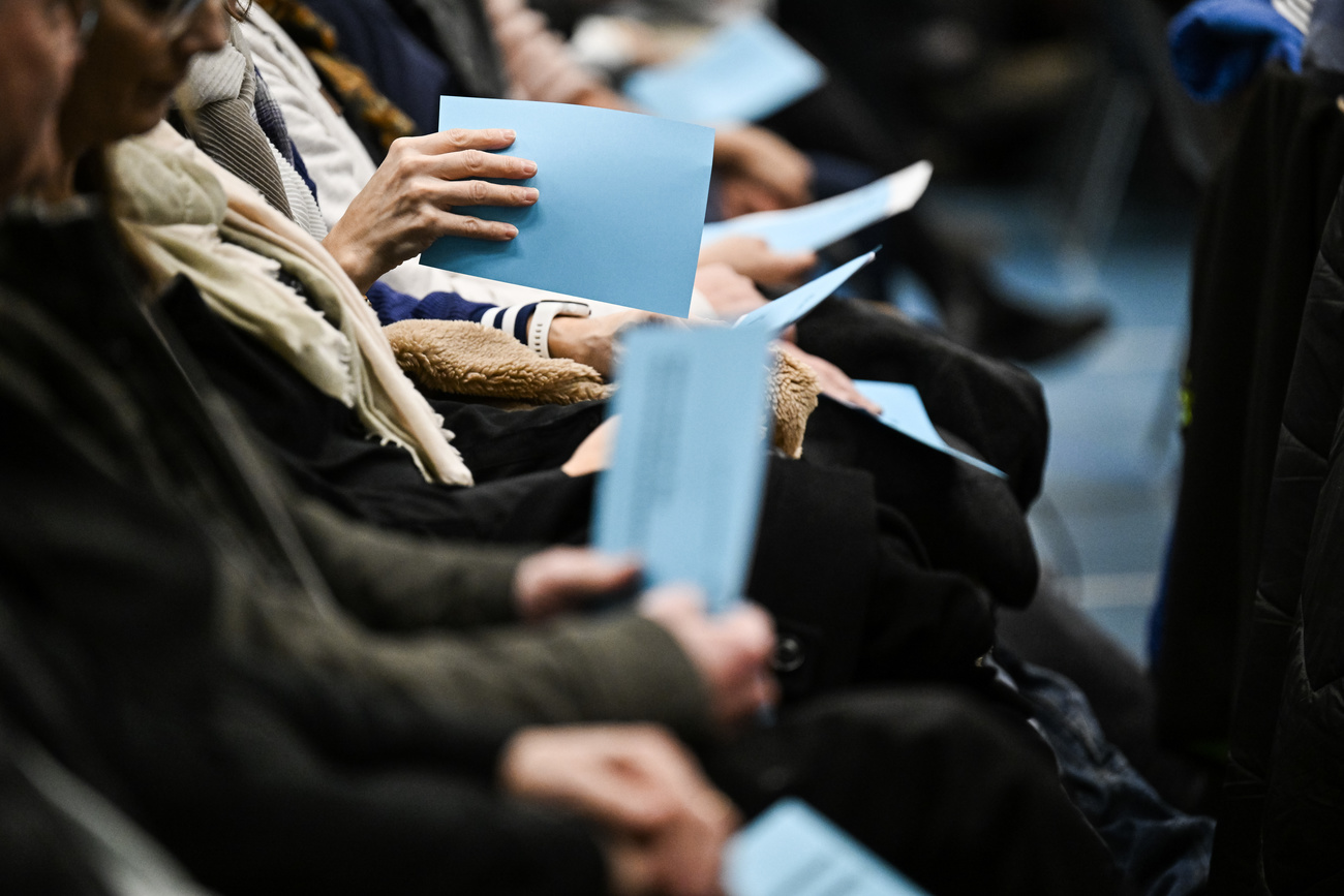 persone sedute con fogli di voto in mano