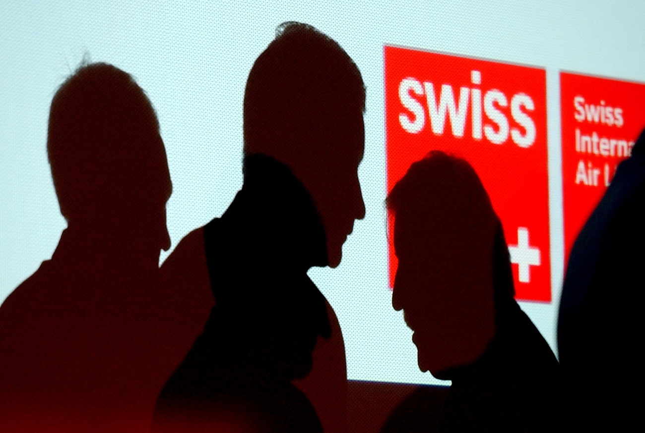 Il logo di Swiss e le ombre di alcune persone.