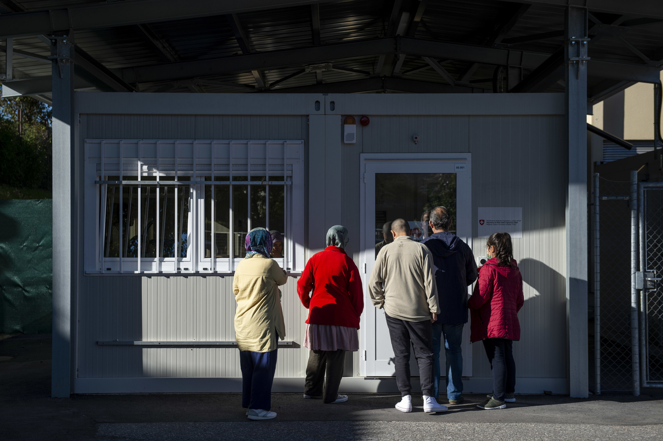 Grupo de pessoas reunidos na frente de uma porta