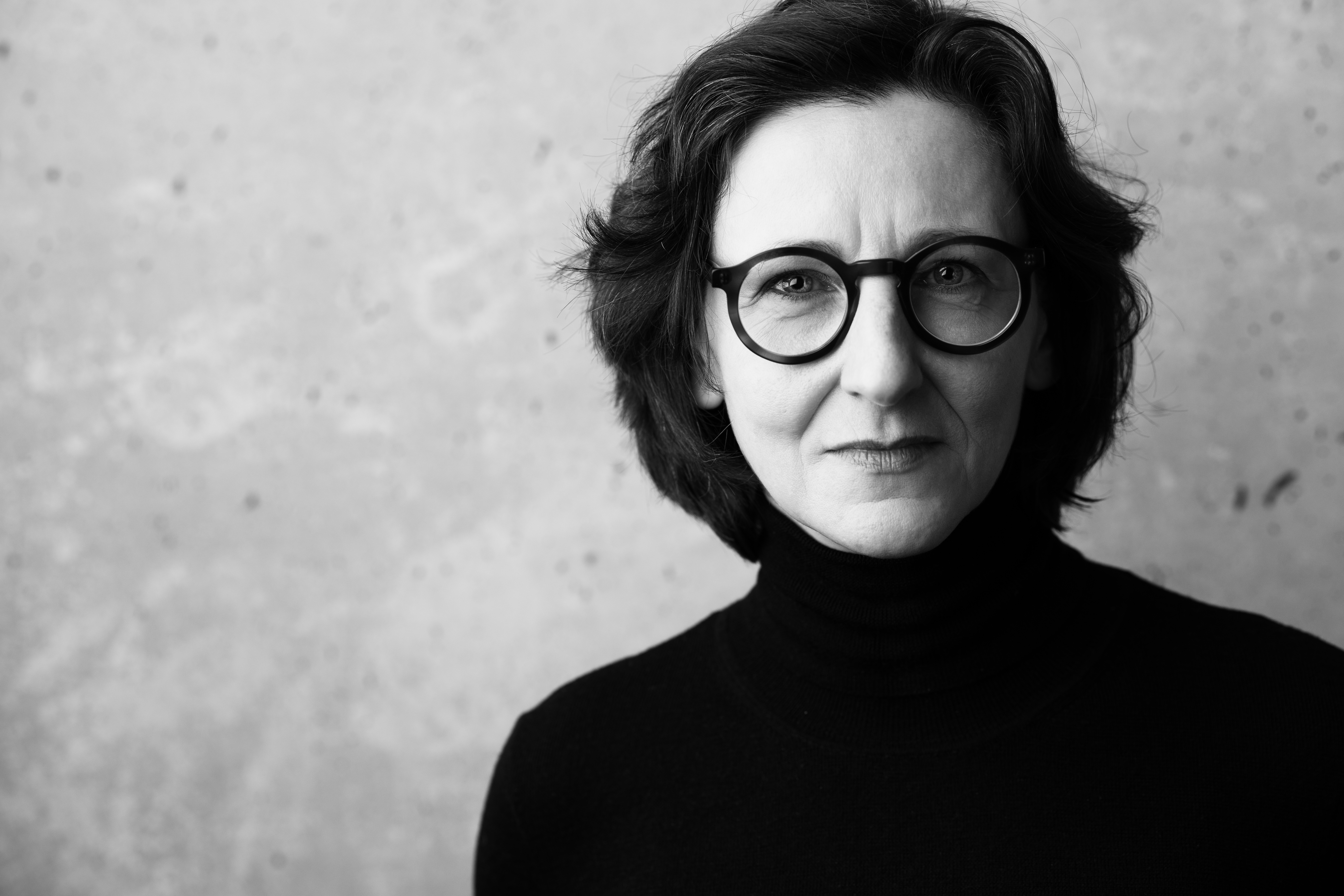 Foto em preto e branco de uma mulher com óculos
