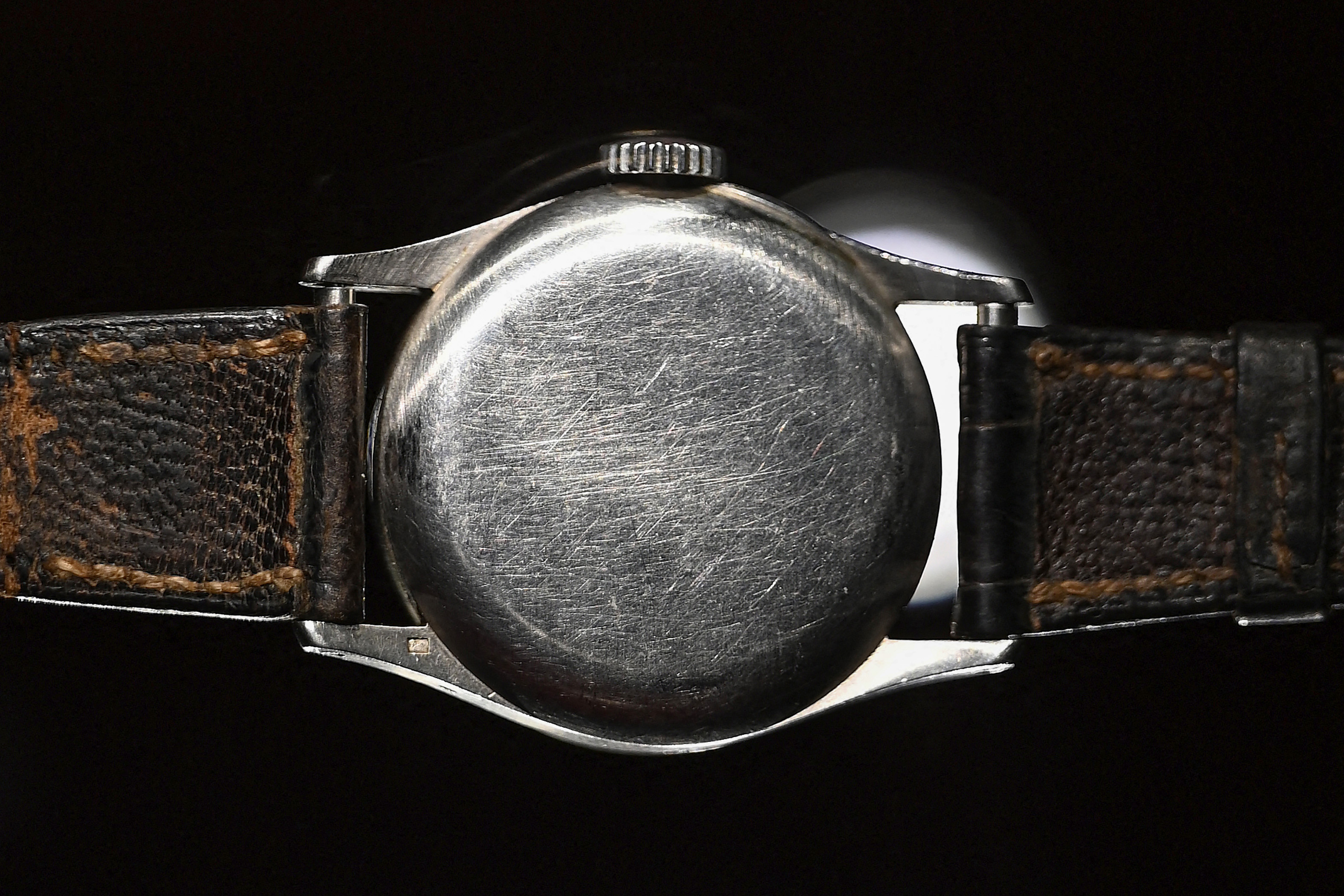 A parte traseira de um relógio com pulseiras de couro.