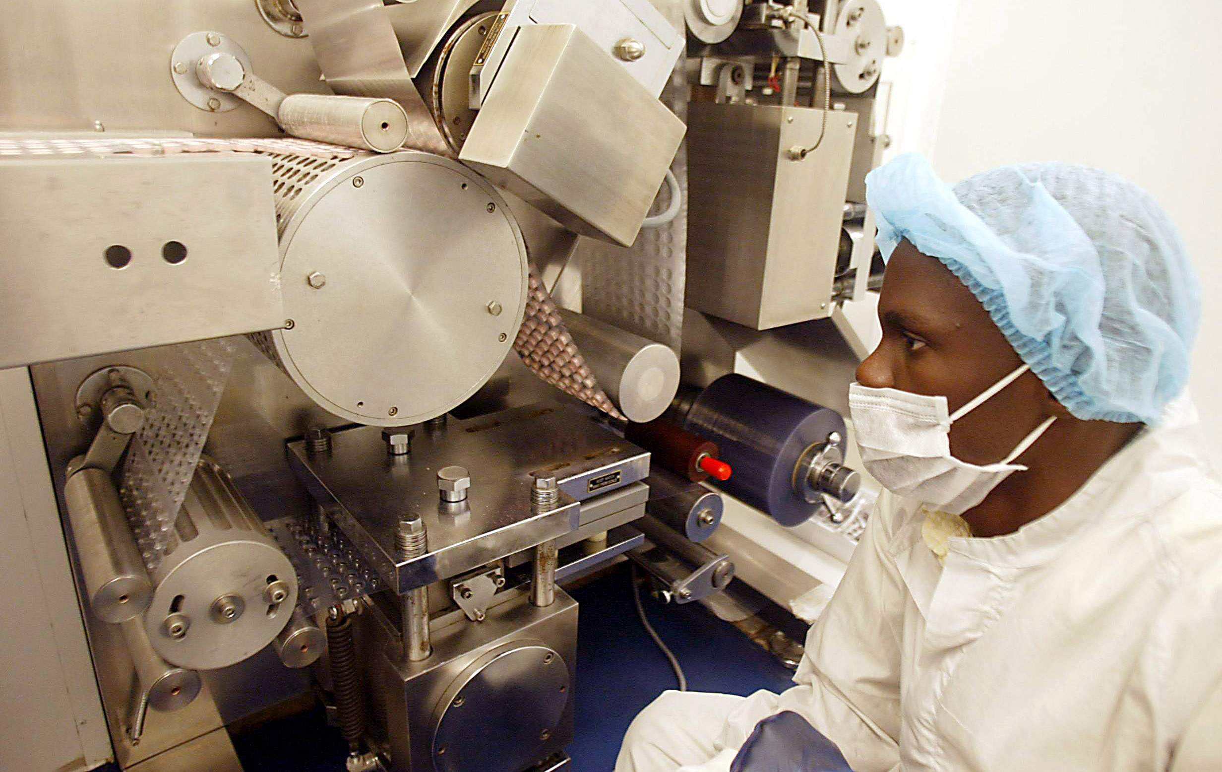 Employee of Gabonese pharmaceutical factory Sogafam checks a machine making pills 04 March 2005.