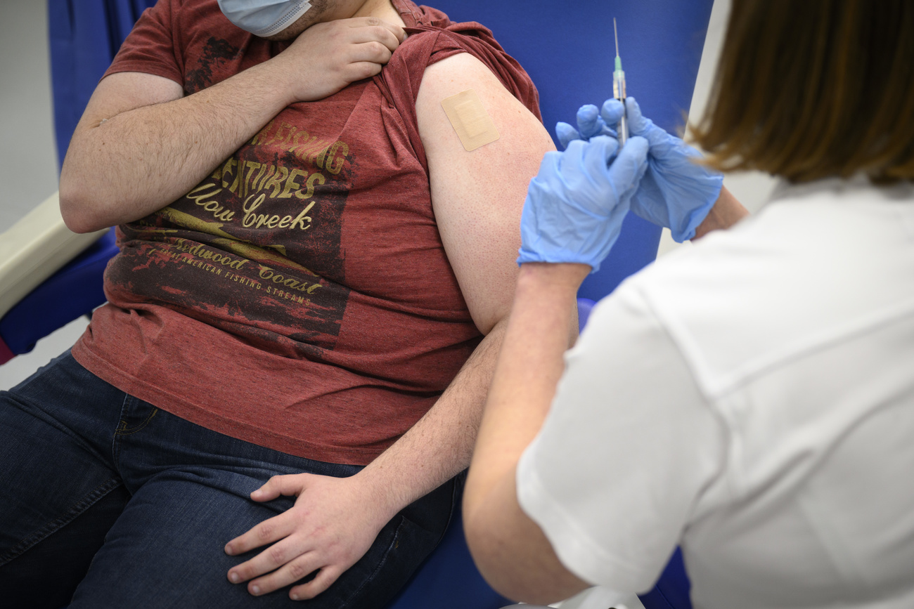 un paziente in sovrappeso si fa iniettare qualcosa nel braccio da un'infermiera
