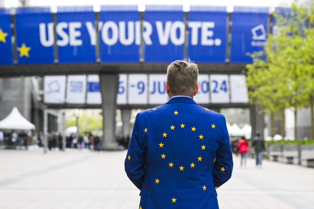 Mann mit EU-Jacket vor einem Werbebanner "Use your vote"