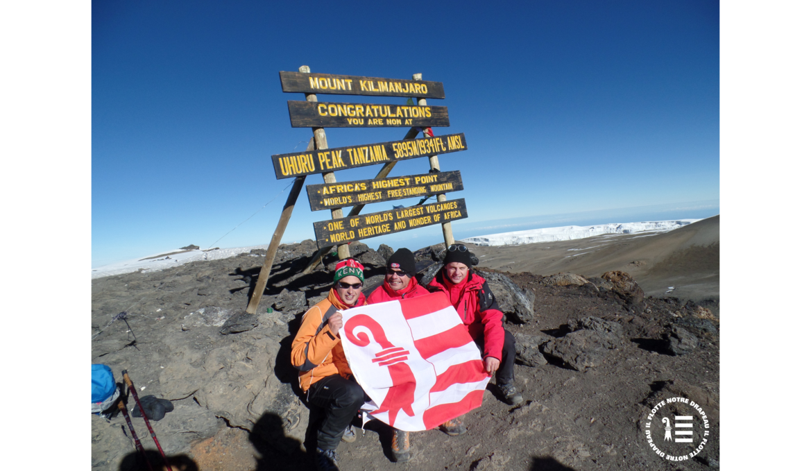 zwei bergsteiger präsentieren die jurassische flagge auf dem kilimandscharo