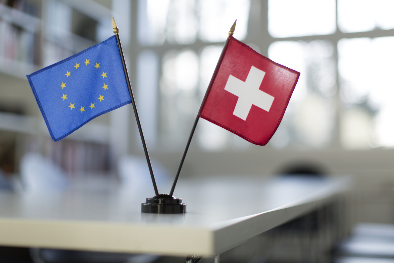 A Swiss and a European Union table flag, captured in an office space.