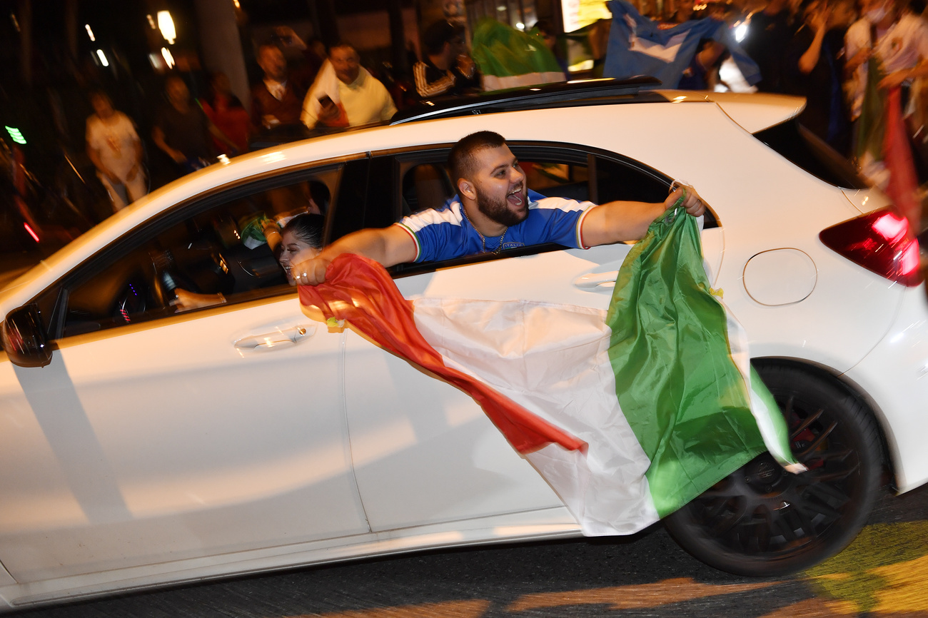 persona sventola bandiera tricolore da un'auto