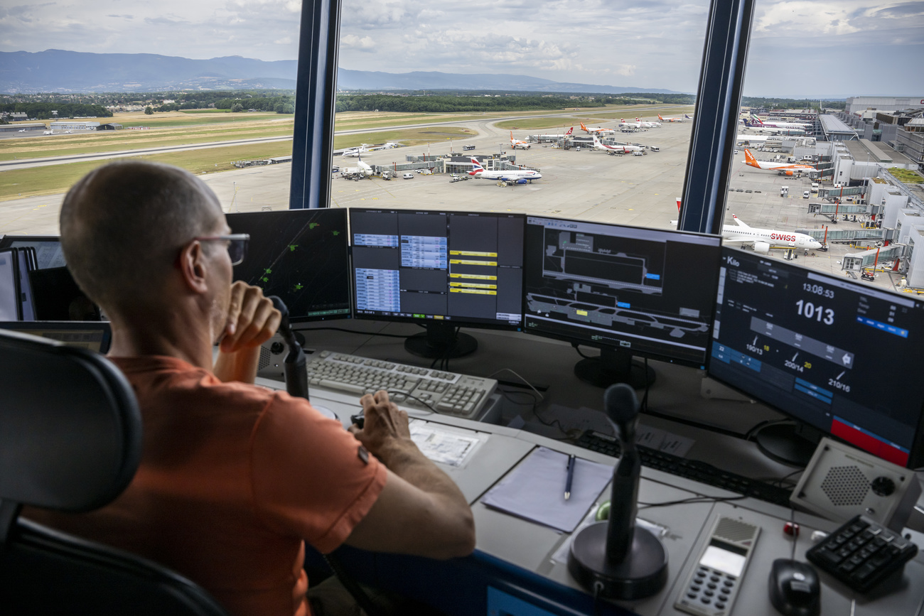 A Skyguide air traffic controller looks at these screens from the control tower at Geneva International Airport
