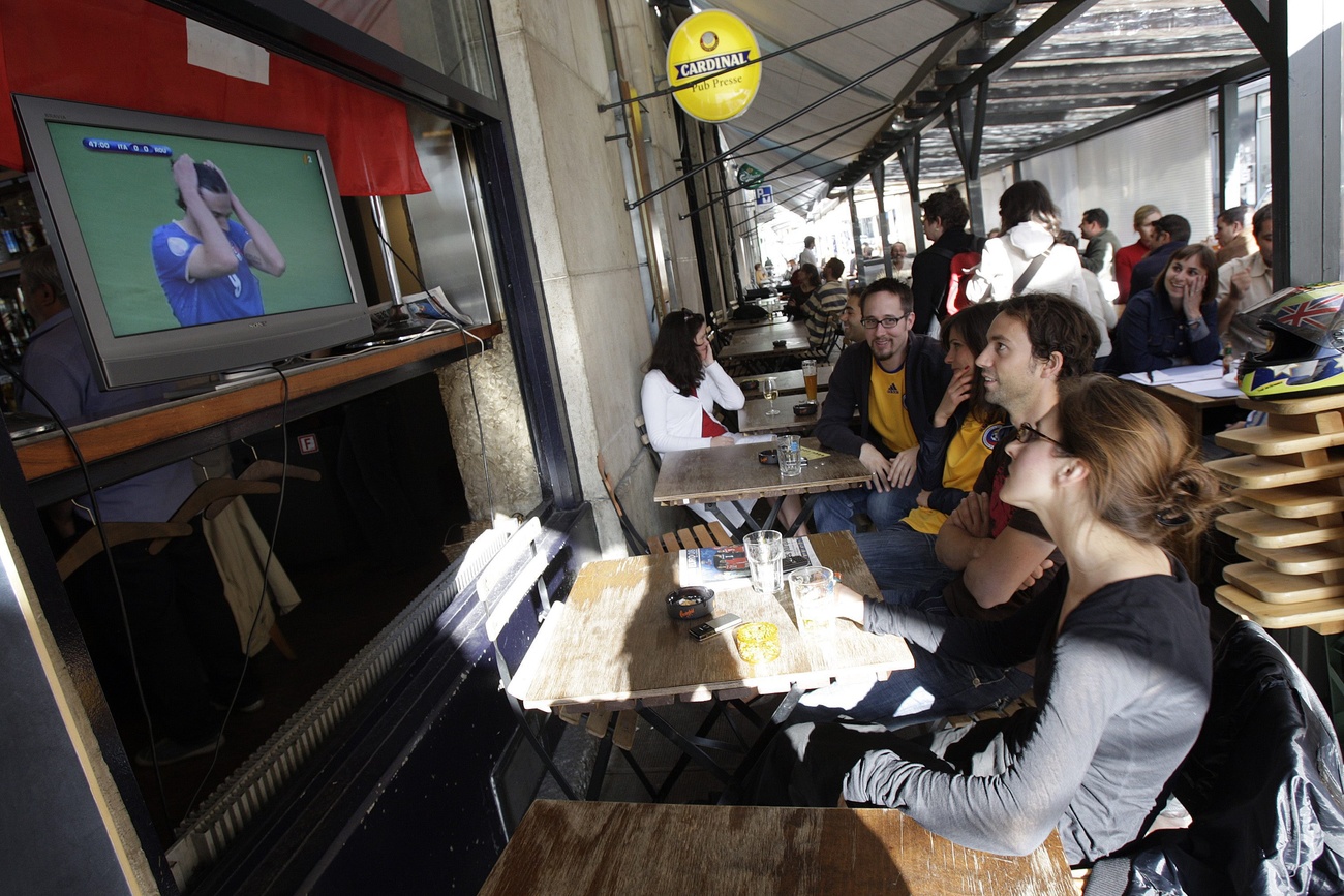 Spettatrici che guardano una partita alla televisione in un locale pubblico.