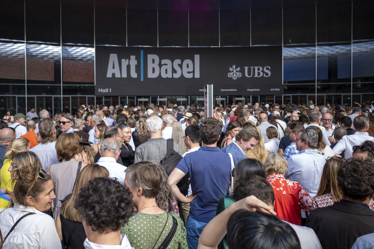a large crowd of people wait to enter the Art Basel fair