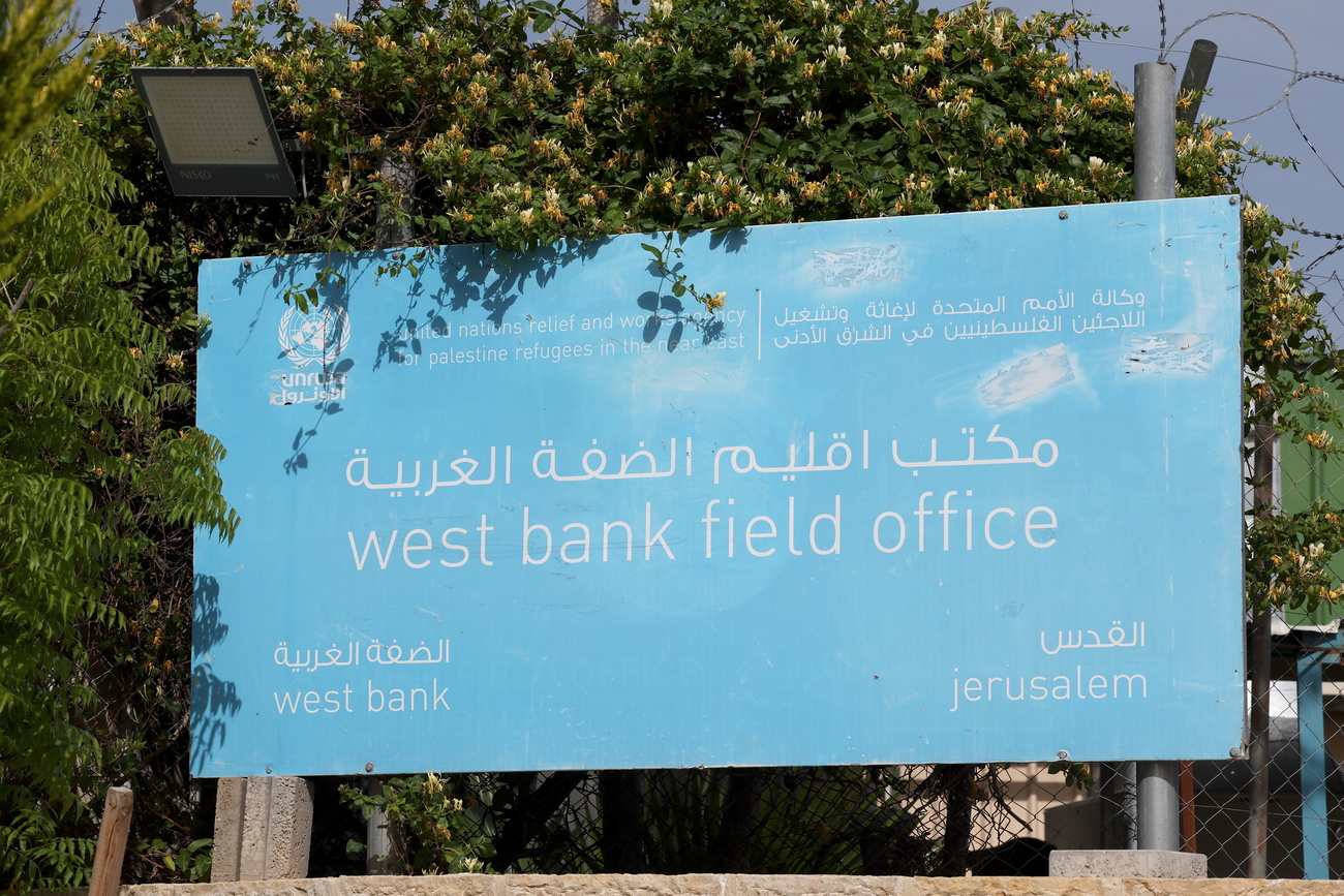 A light blue sign surrounded be trees. In big letters at the centre it says, ‘west bank field office’. IAt the top in smaller lettering it says United Nations Relief and Works Agency for Palestine Refugees in the Near East (UNRWA), with ‘west bank’ in the bottom left and ‘Jerusalem’ bottom right.