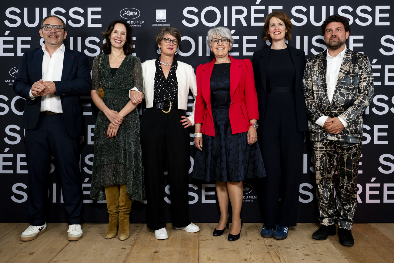 The official side of Swiss cinema throwing its weight in Cannes: Federal Councillor Elisabeth Baume-Schneider (center, in red) poses with the Swiss delegation during the ‘Soirée Suisse’ at the 77th edition of the Cannes Film Festival: from left, Laurent Steiert, co-director of the Federal Department of Culture (film section); Catherine Muehlemann, president of Swiss Films; Carine Bachmann, director of the FDC; Nadine Adler, co-director of the FDC; Nicola Ruffo, director of Swiss Films.