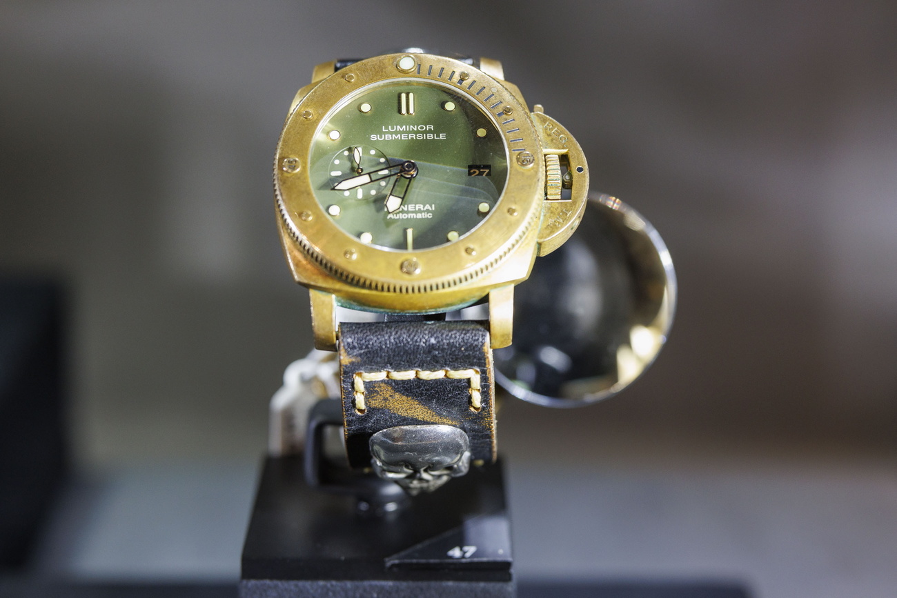 Uhr mit dickem Goldrahmen und Lederarmband mit eingearbeitetem, metallenem Totenkopf