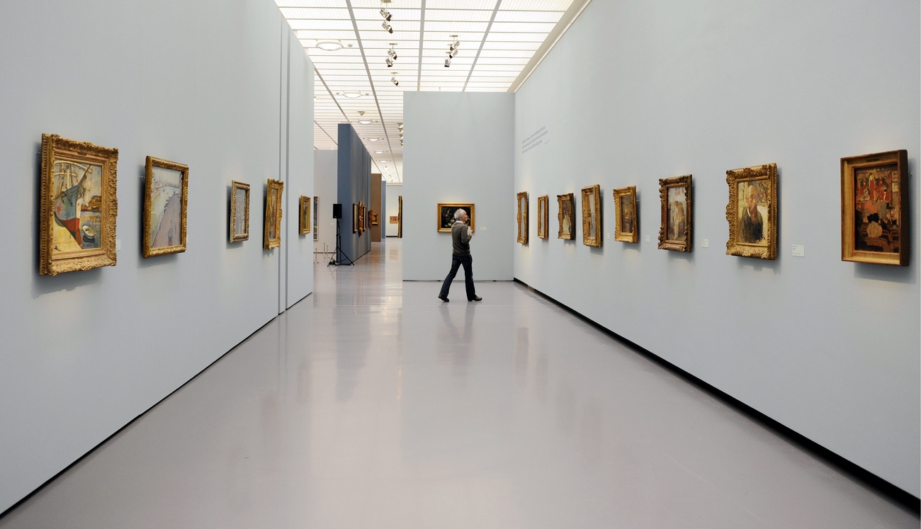 An art gallery with framed paintings hanging on the walls.