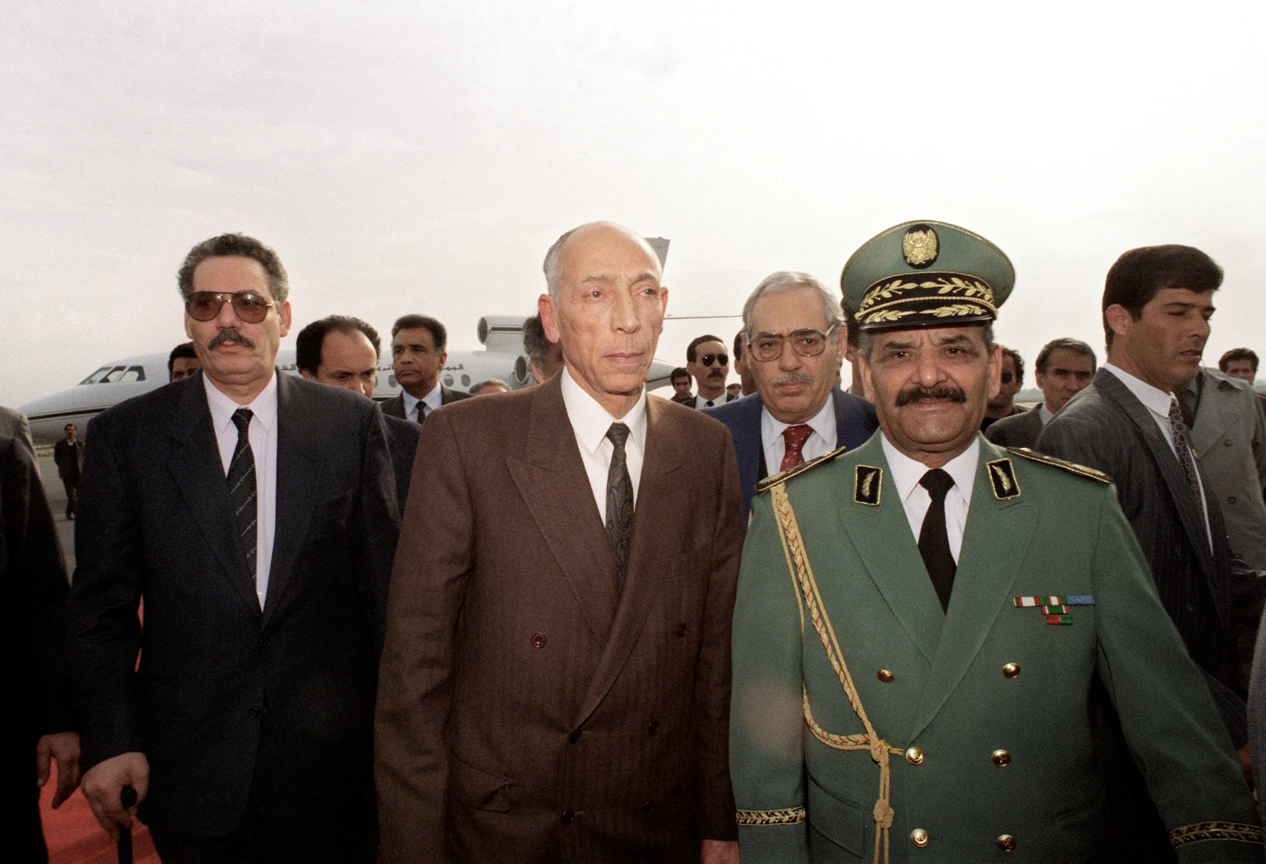 在擔任國防部長期間，哈立德·內扎爾(Khaled Nezzar，左)是阿爾及利亞內戰中阿爾及利亞政府與伊斯蘭組織衝突中的關鍵人物。在他旁邊的是高級國務委員會主席穆罕默德·布迪亞夫(Mohamed Boudiaf，中)和軍隊首腦阿卜杜勒馬利克·蓋尼茲亞(Abdelmalek Gueneizia，右)，1992年。