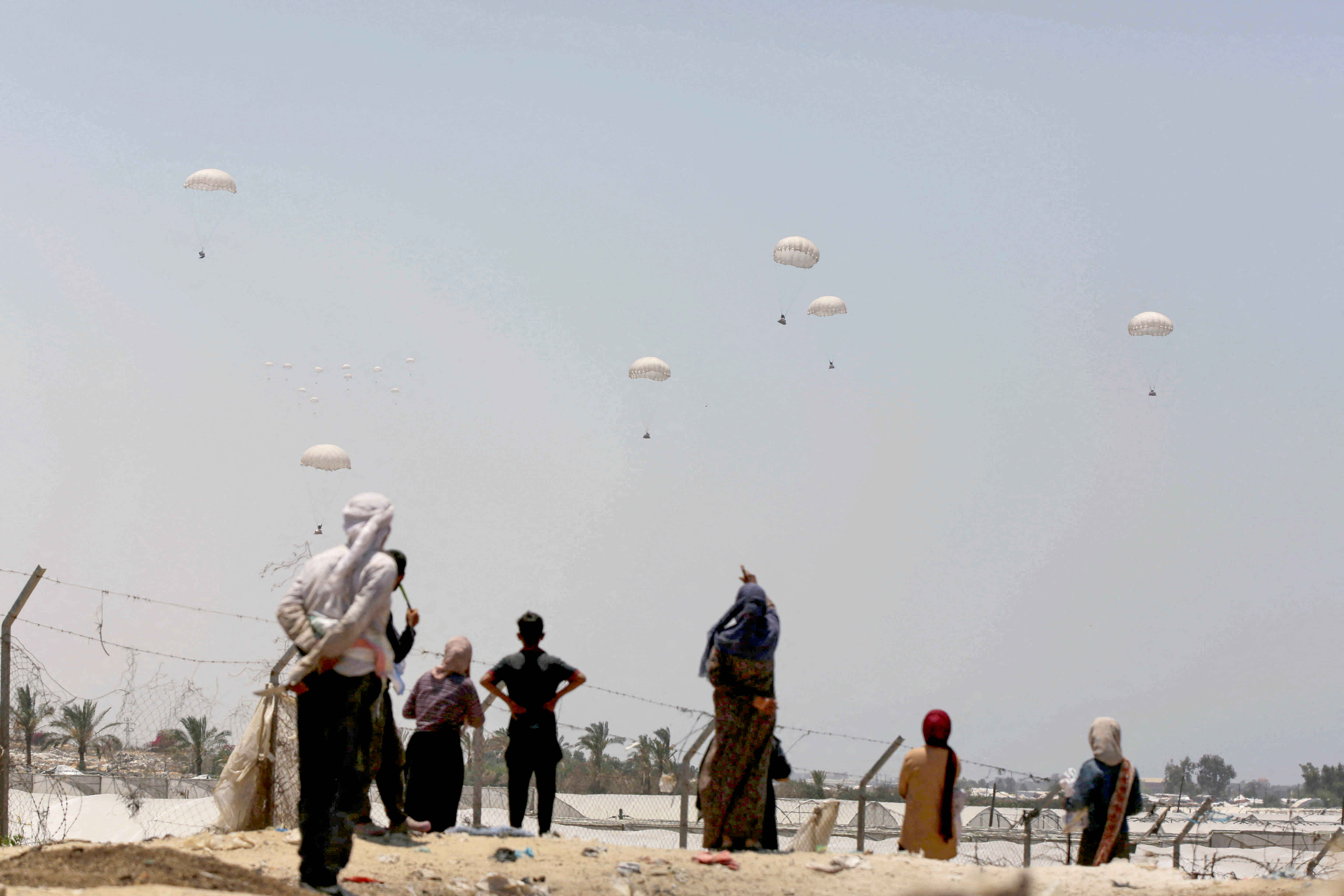 humanitarian aid packages land with the help of parachutes in Gaza