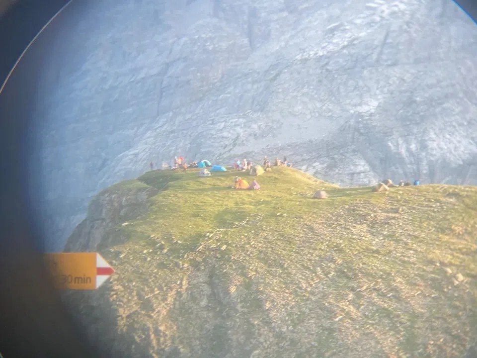 A wild campsite above Lake Limmern in canton Glarus, photographed through a telescope. This is how the situation looks near the Muttseehütte hut.