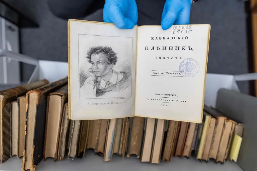 hände halten alt aussehendes buch von pushkin