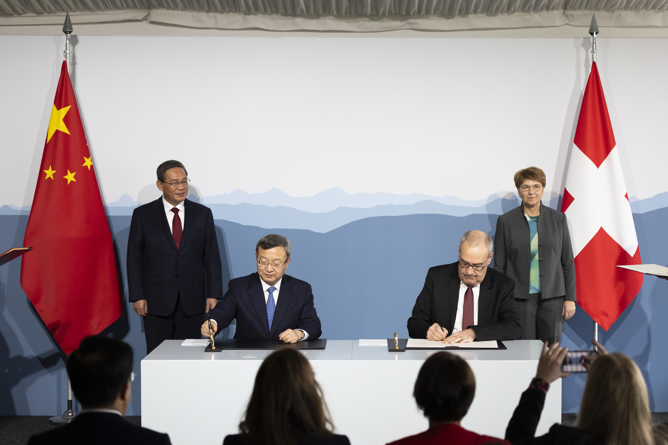 Swiss Federal Minister Guy Parmelin, front right, and Wang Shouwen, Chinese Vice Minister of the Ministry of Commerce, front left, sign a joint statement on the free trade agreement, January 2024.