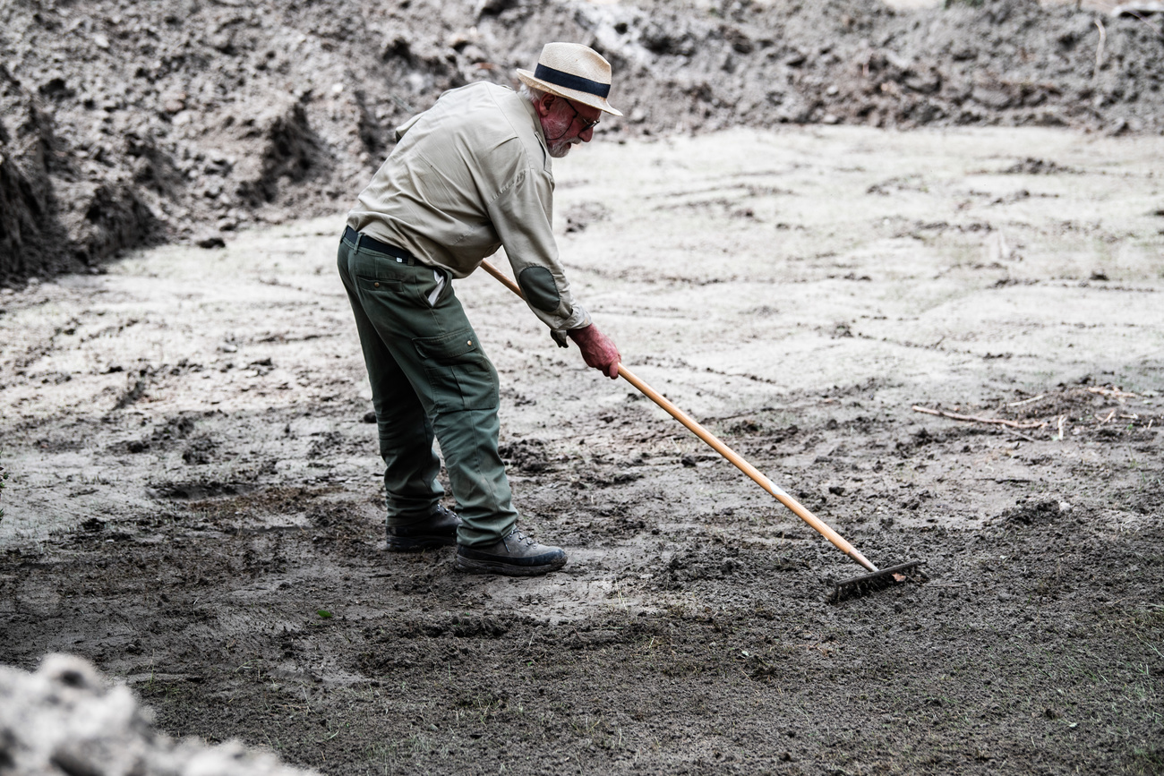 A man clearing up debris after the landslide in canton Ticino