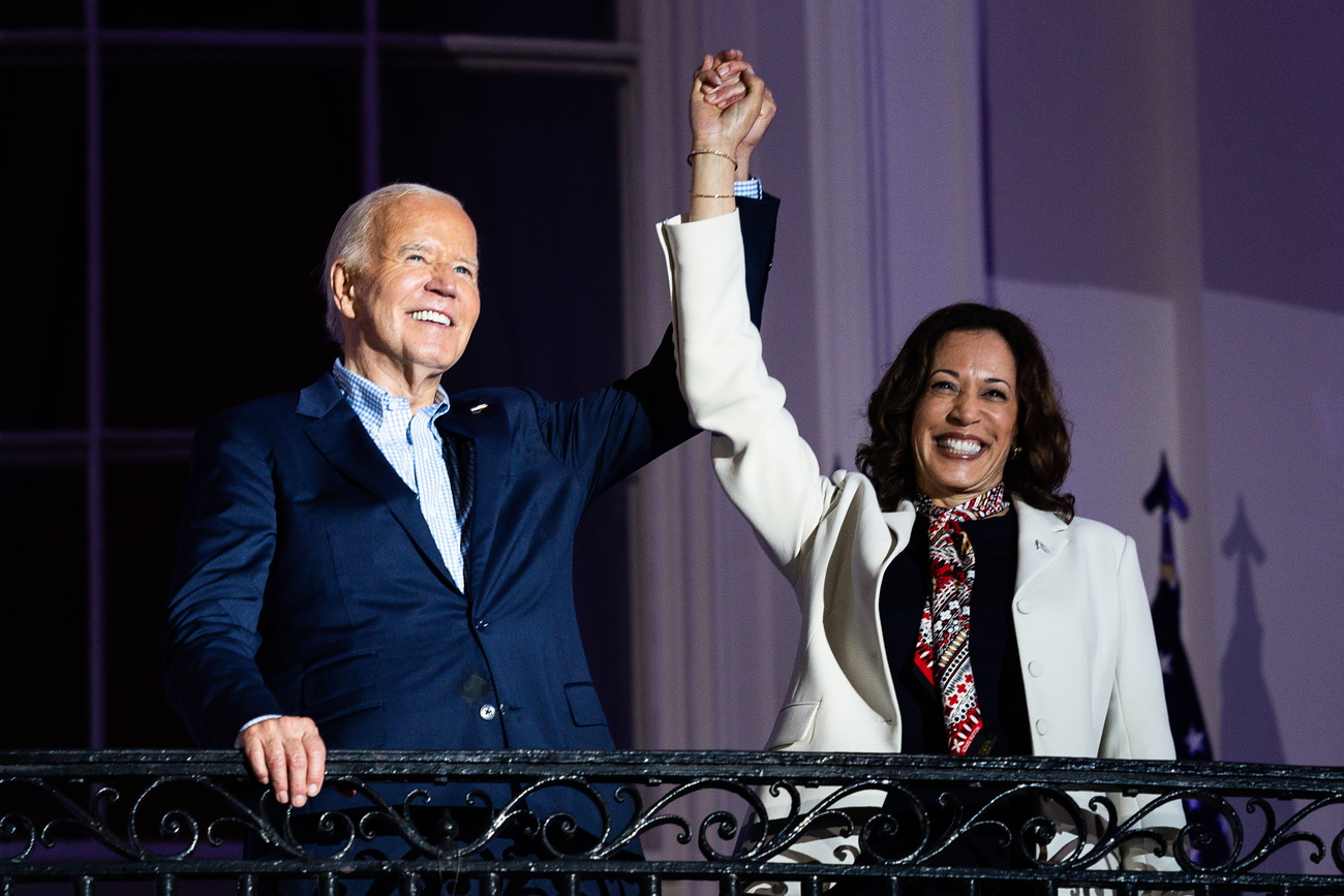 Photo of Joe Biden and Kamala Harris cheering and holding hands