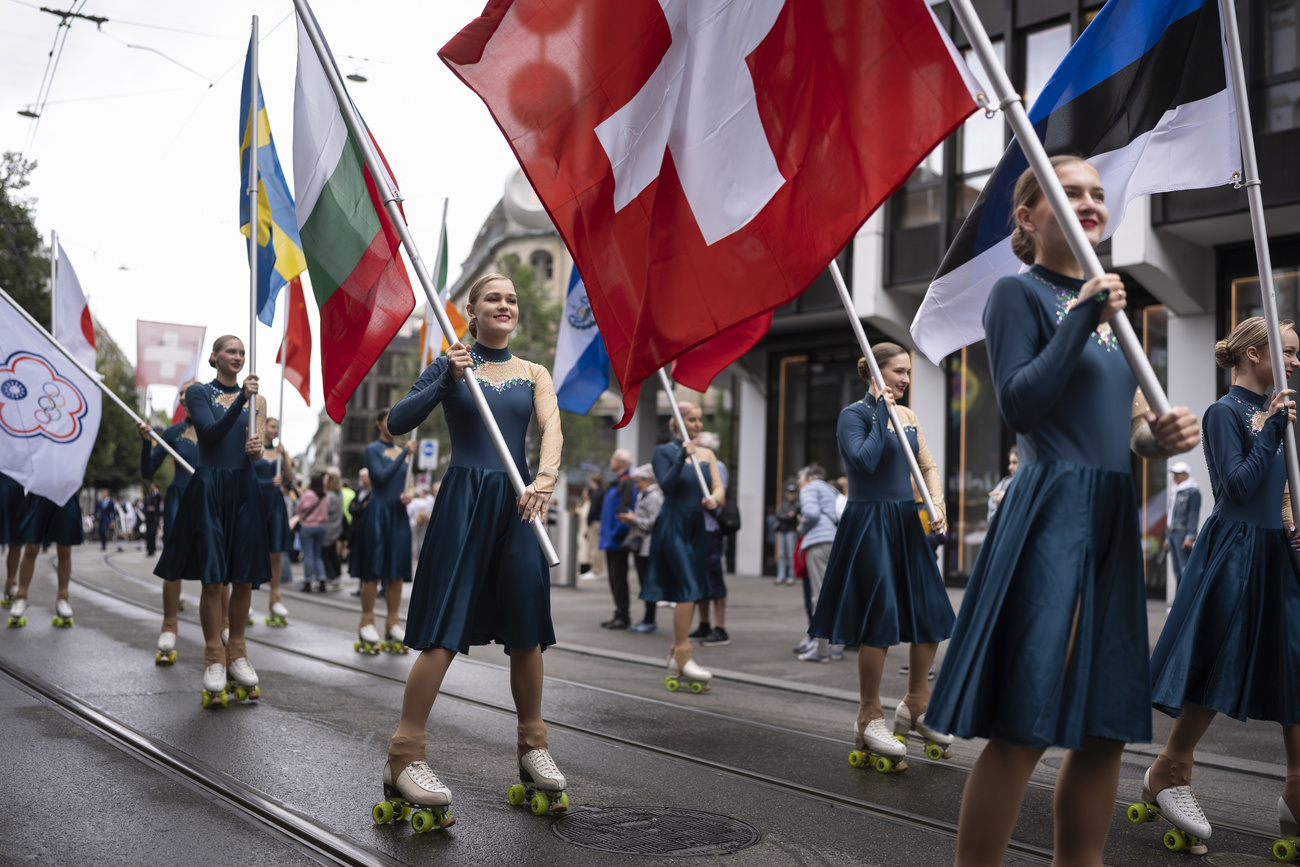 swiss flag being carried by girls on roller blades