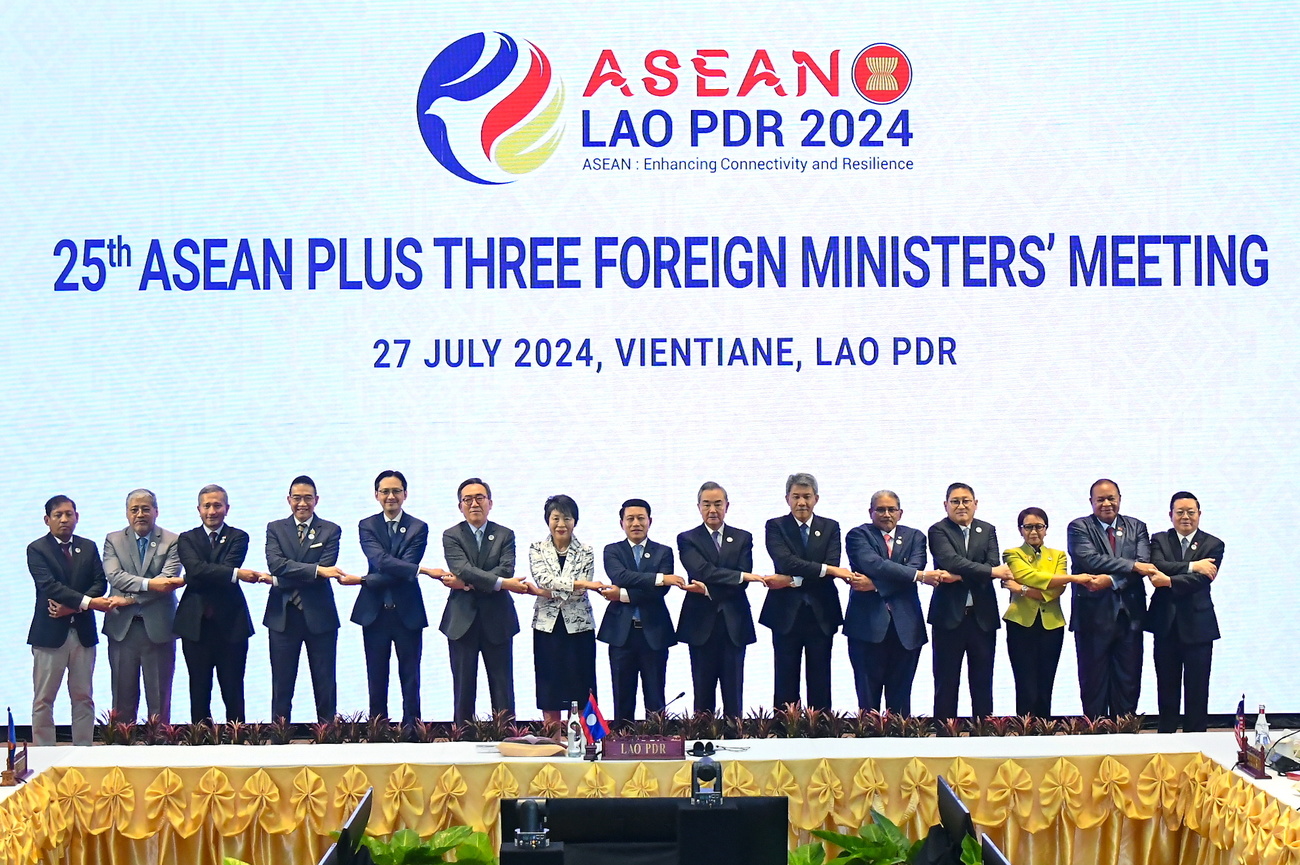 A handout photo made available by Thailand's Ministry of Foreign Affairs shows (L-R) Myanmar Permanent Foreign Secretary Aung Kyaw Moe, Philippines Secretary of Foreign Affairs Enrique Manalo, Singapore's Minister of Foreign Affairs Vivian Balakrishnan, Thai Minister of Foreign Affairs Maris Sangiampongsa, Vietnamese Deputy Foreign Minister Do Hung Viet, South Korean Foreign Minister Cho Tae-yul, Japanese Foreign Minister Yoko Kamikawa, Laos Minister of Foreign Affairs Saleumxay Kommasith, China's Foreign Minister Wang Yi, Malaysian Minister of Foreign Affairs Mohamad Hasan, and Brunei's Minister of Foreign Affairs Dato Erywan Pehin Yusof, Cambodian Foreign Minister Sok Chenda Sophea, Indonesian Minister of Foreign Affairs Retno Marsudi, East Timor Foreign Minister Bendito dos Santos Freitas, and ASEAN Secretary-General Kao Kim Hourn holding hands for a group photo at the 25th ASEAN Plus Three Foreign Ministers' meeting, part of the 57th ASEAN Foreign Ministers' meeting, in Vientiane, Laos, 27 July 2024. Foreign Ministers of the Association of Southeast Asian Nations (ASEAN) convened at a summit hosted by Laos in the capital of Vientiane to tighten diplomatic relations and discuss the ongoing civil unrest in Myanmar and tension in the South China Sea.