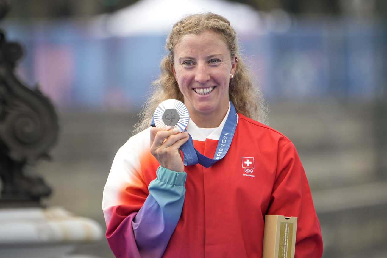 Eine Frau zeigt ihre Silbermedaille