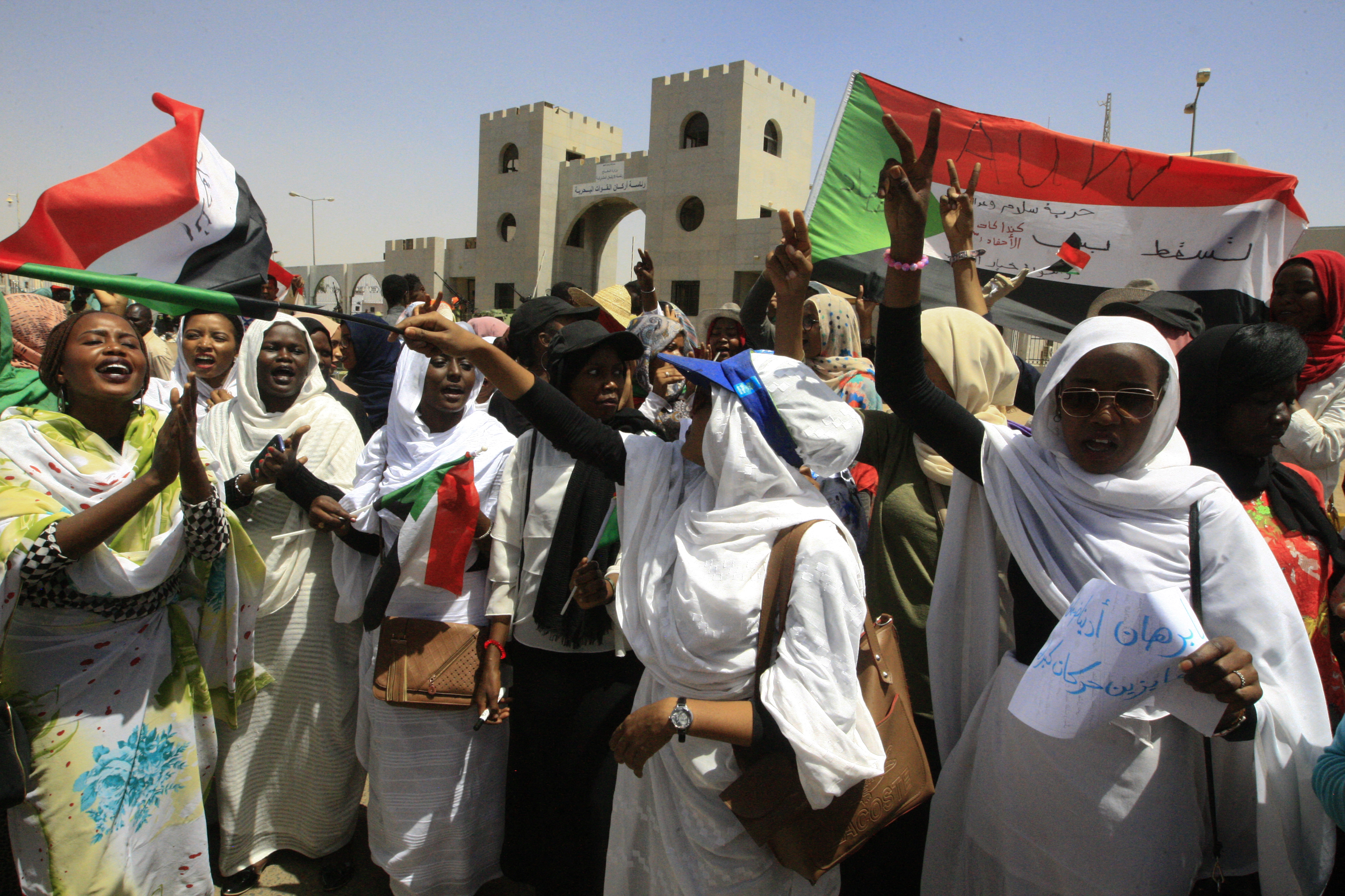 donne sudanesi sventolano la bandiera nazionale durante una manifestazione