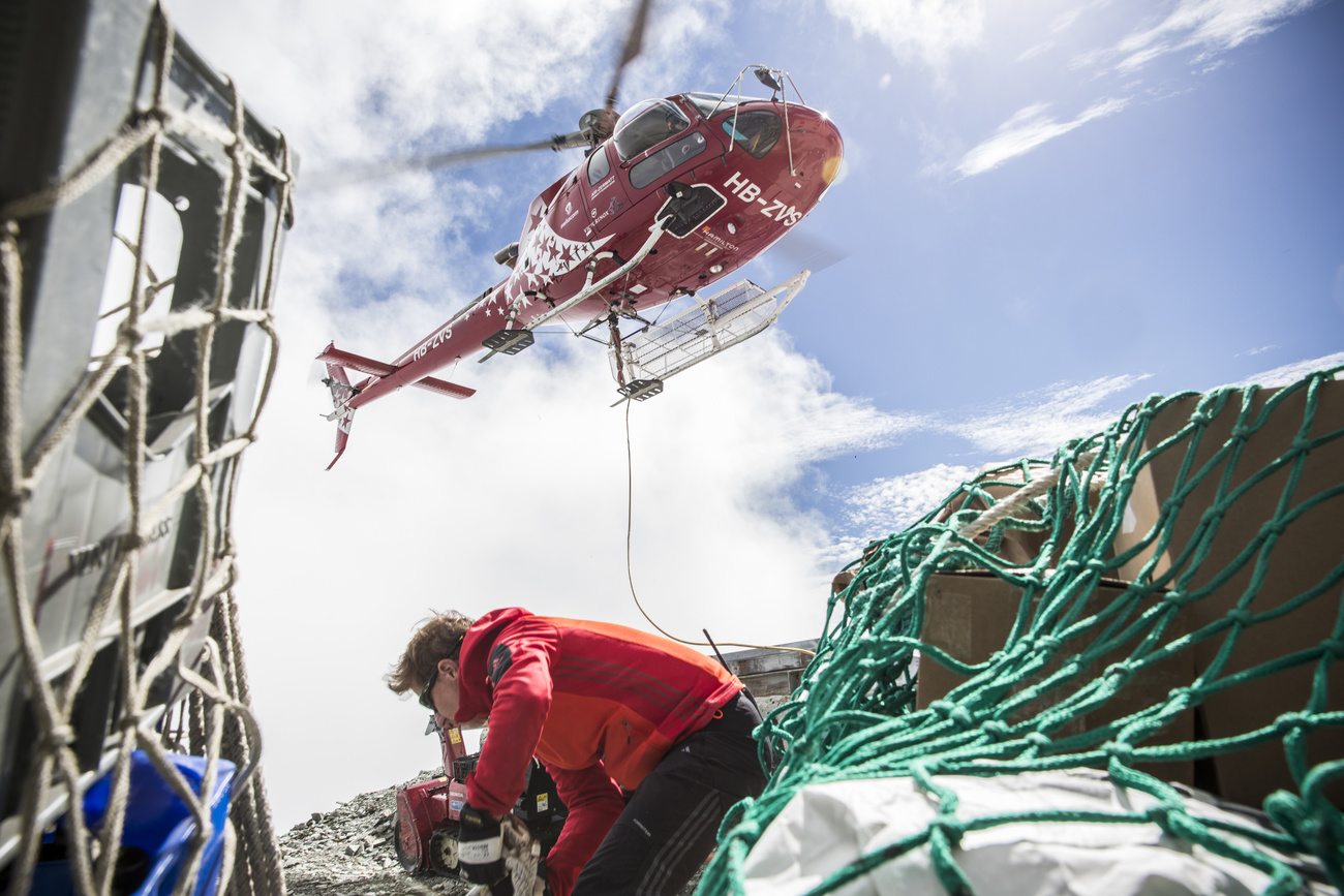 Picture of helicopter in the sky and person unloading supplies