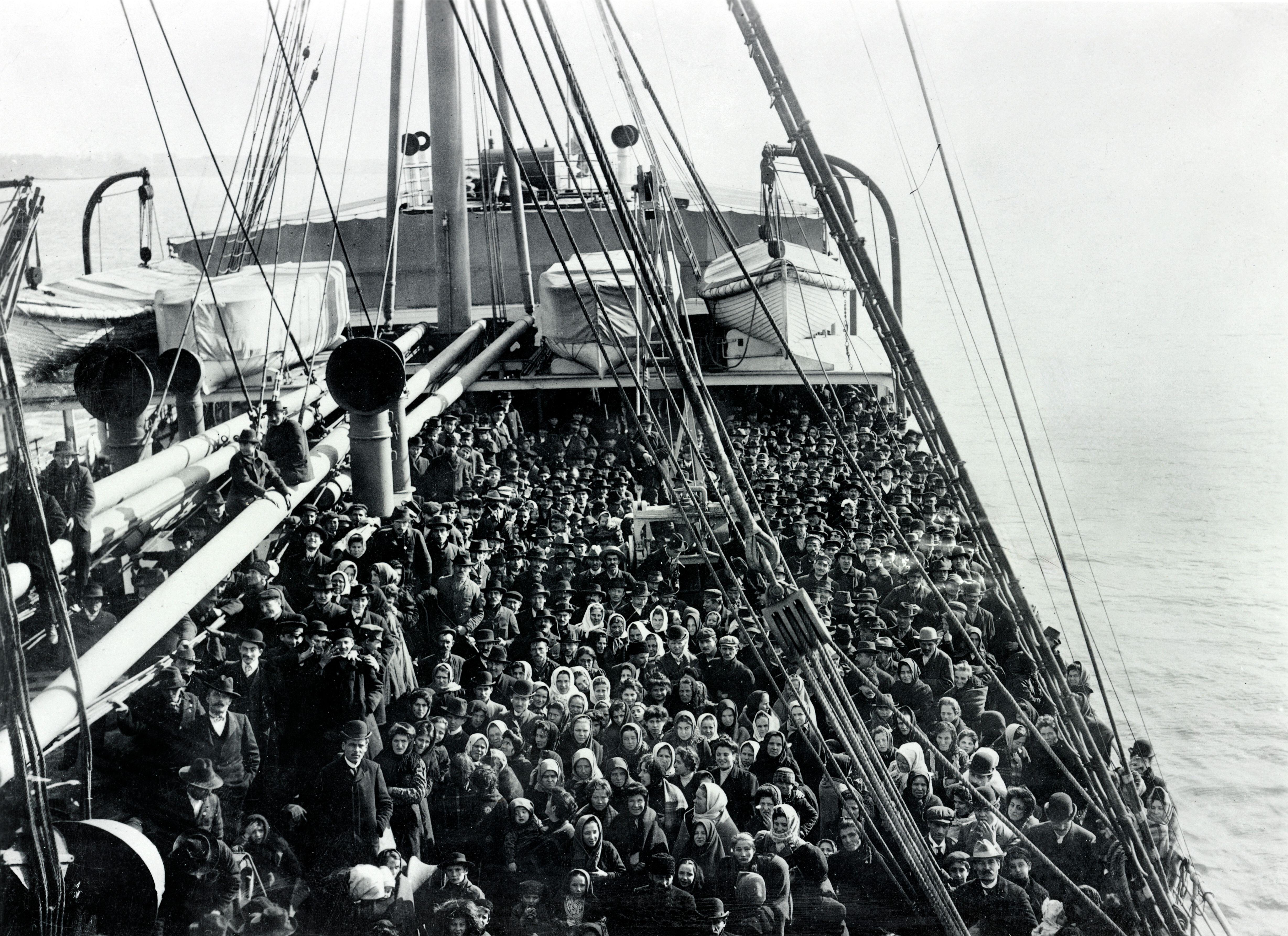 Foto in bianco e nero, gruppo di emigranti sul ponte di una nave