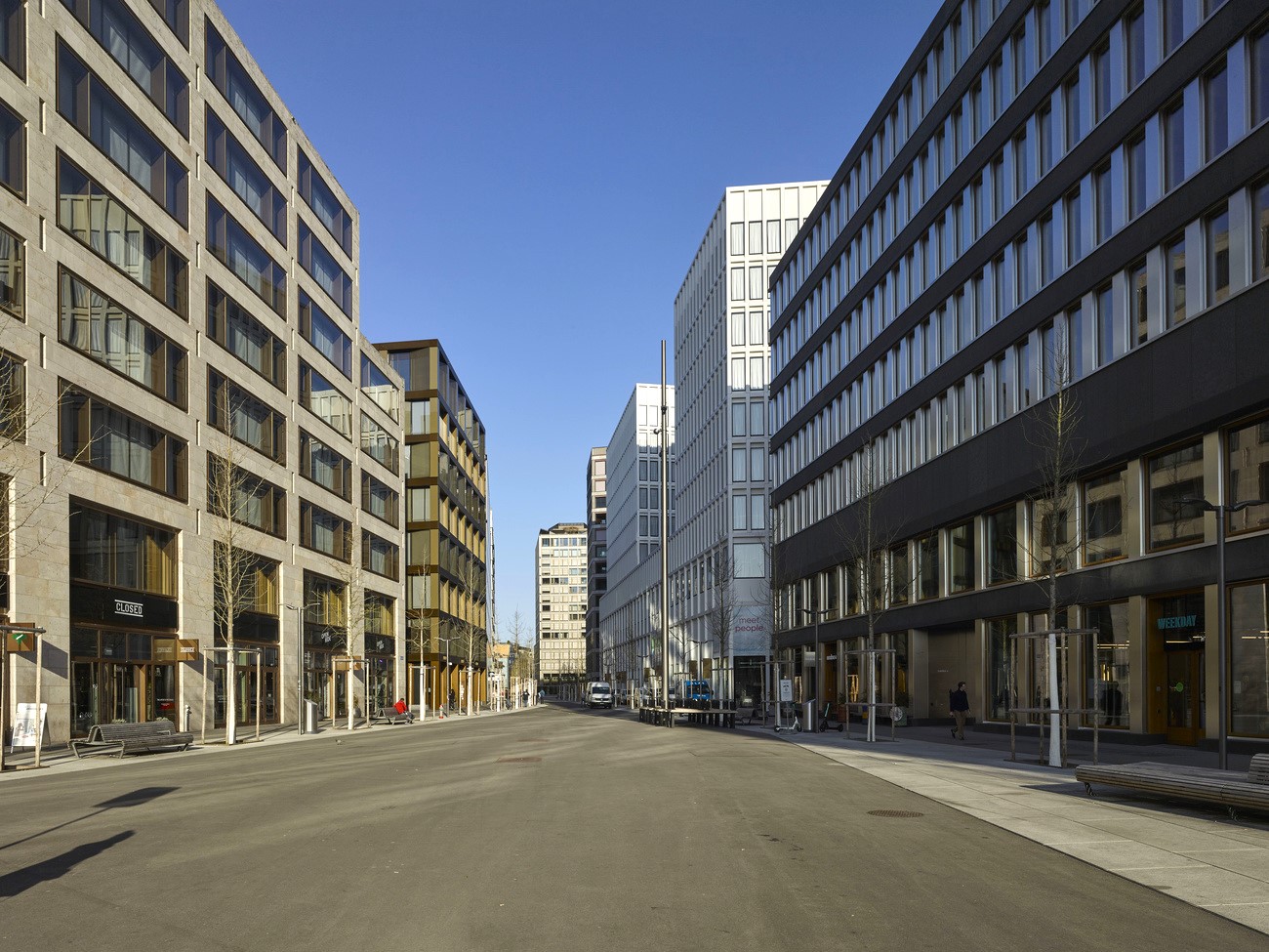 Eine Betonstrasse ohne Bäume zwischen Hochhäusern