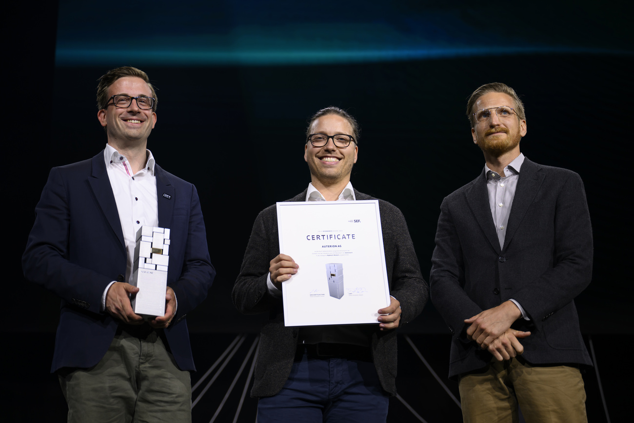 Trois hommes posant à la remise d’’un diplôme