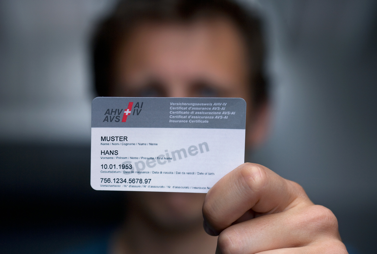 A man shows a prototype of the new insurance certificate of the AHV-IV (AHV: Federal old-age and bereaved people insurance/IV: Disabled people insurance) with the name of the insured party, his date of birth and the individual insurance number, pictured in a studio in Zurich,