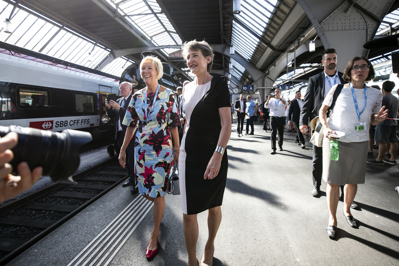 Duas mulheres em uma estação de trem.