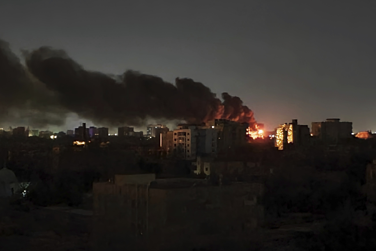 Smoke rises over the horizon as a fire burns after a strike in Khartoum, Sudan, Sunday, April 16, 2023.