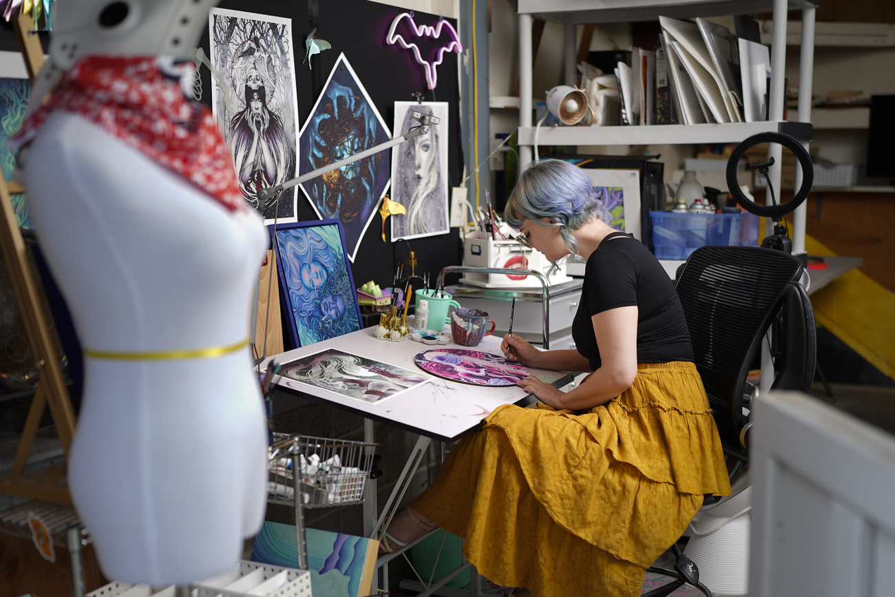 L'artista Kelly McKernan dipinge nel proprio studio