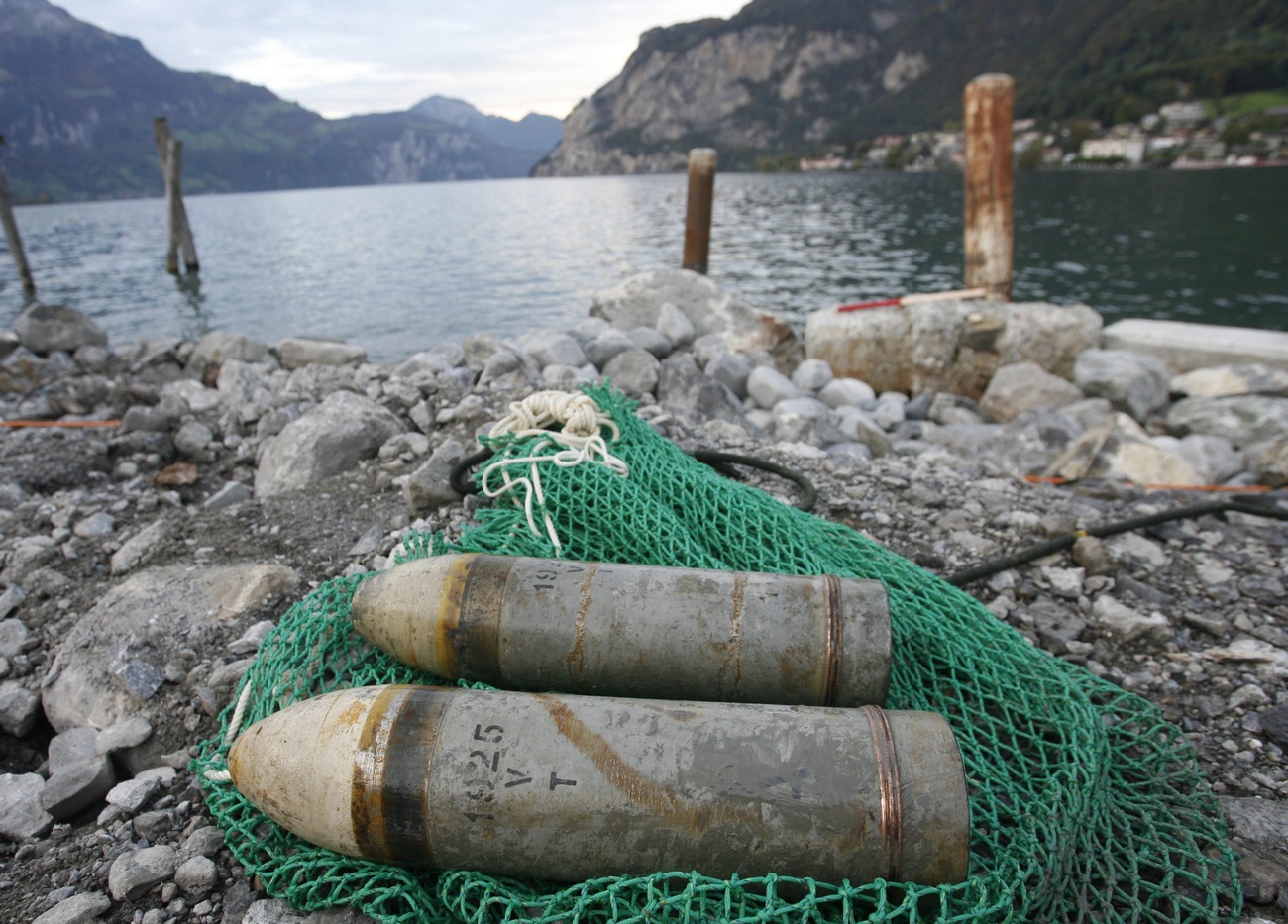 Two 1x12 cm mine shells with fuse, bottom, and without fuse, top, recovered by Swiss Army experts, which were used for 12 cm field howitzers 1912, lie on the shore of Lake Lucerne in Gersau on Tuesday, 7 October 2008. Swiss Army experts on Tuesday fished out samples of around 3360 tonnes of various types of dumped ammunition from Lake Lucerne, which were dumped in the 1960s. (KEYSTONE/Urs Flueeler)