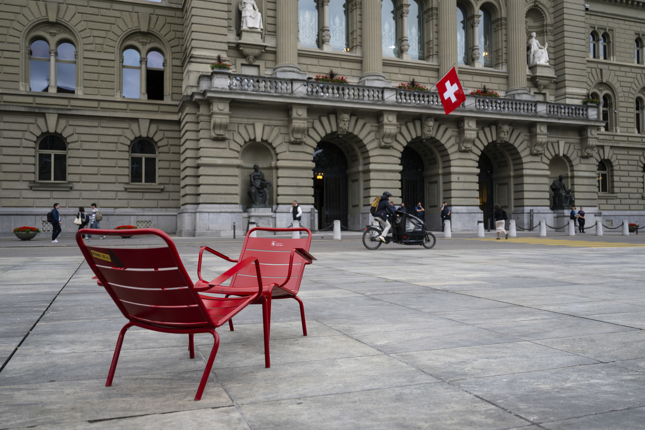 Zwei rote Stühle auf dem Bundesplatz, das Bundeshaus im Hintergrund