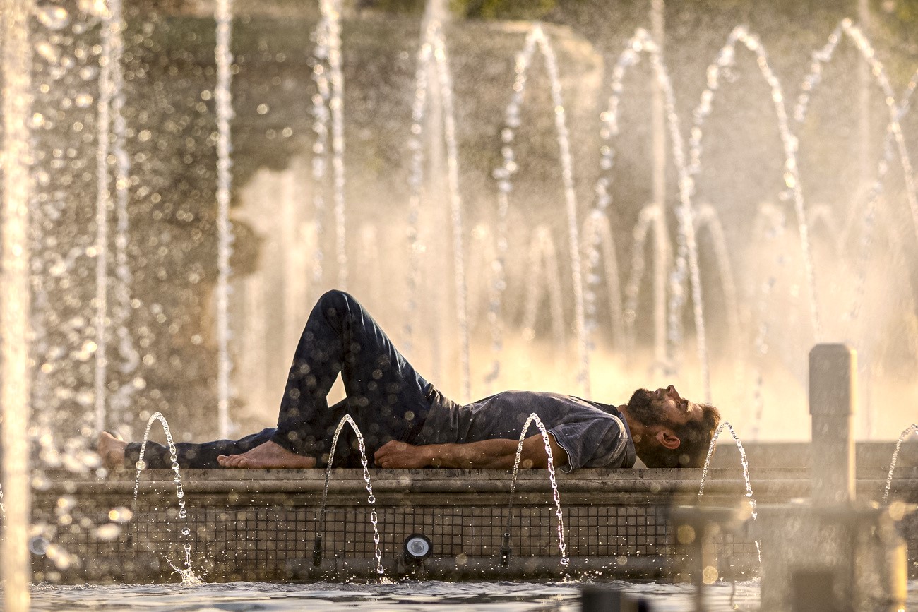 Ein Mann liegt an einem Brunnen