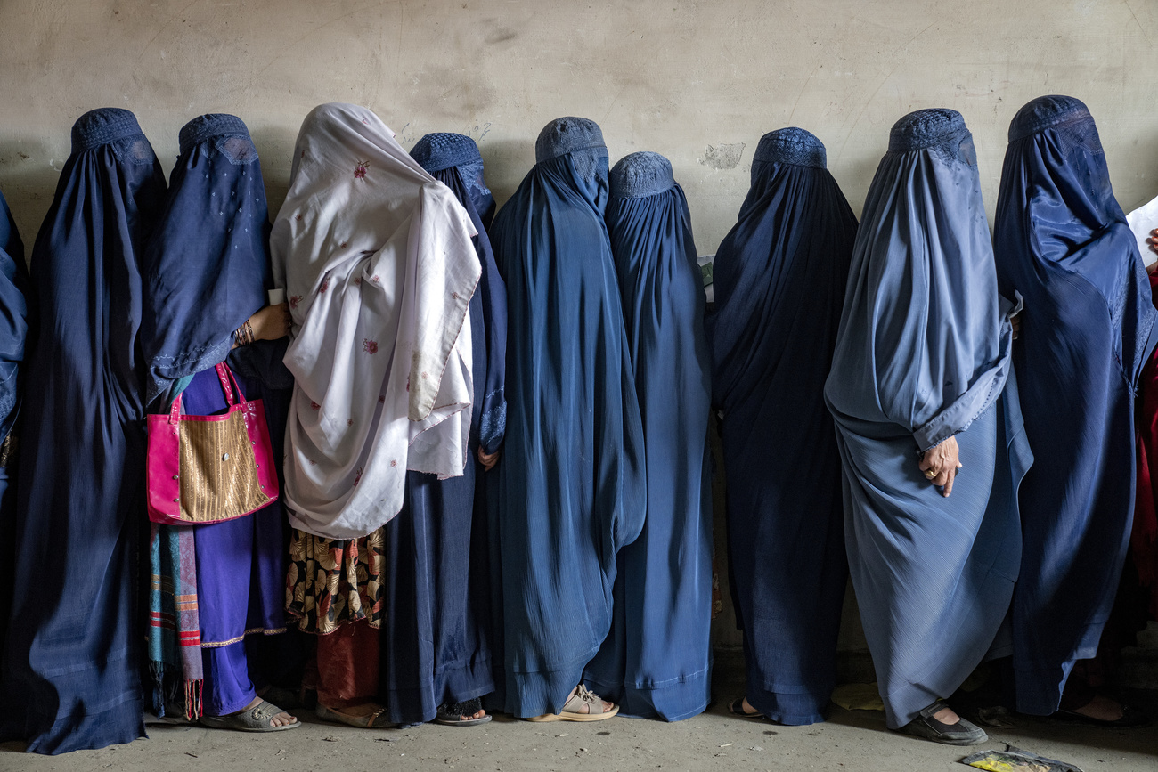 Afghan women wait to receive food rations distributed by a humanitarian aid group in Kabul, Afghanistan, May 23, 2023.