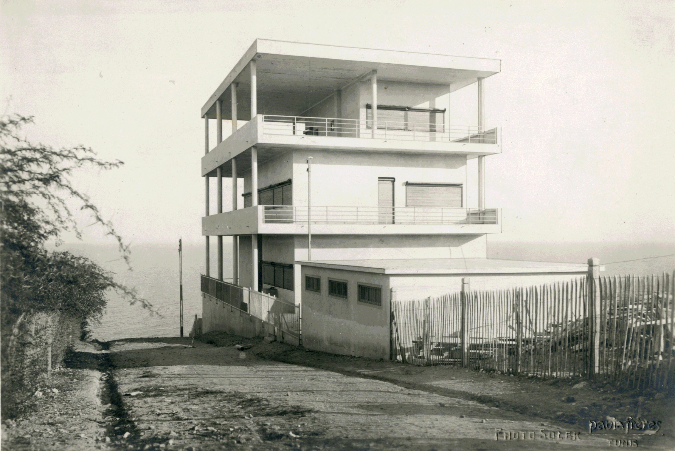 Foto em preto e branco de uma casa em construção.