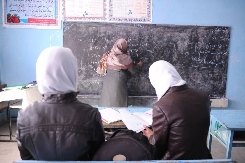 Due ragazze con il velo osservano la docente alla lavagna