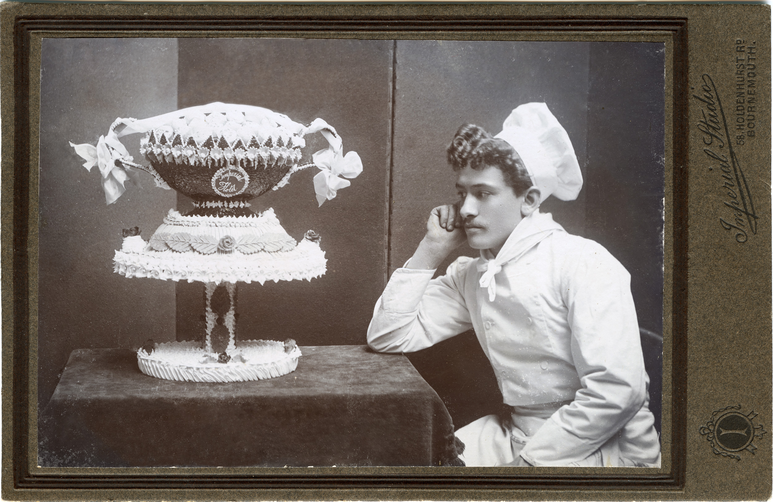 Pastry chef Aristide Luminati (1880-1967) in Gosport, England, with the cake he made for his graduation examination.