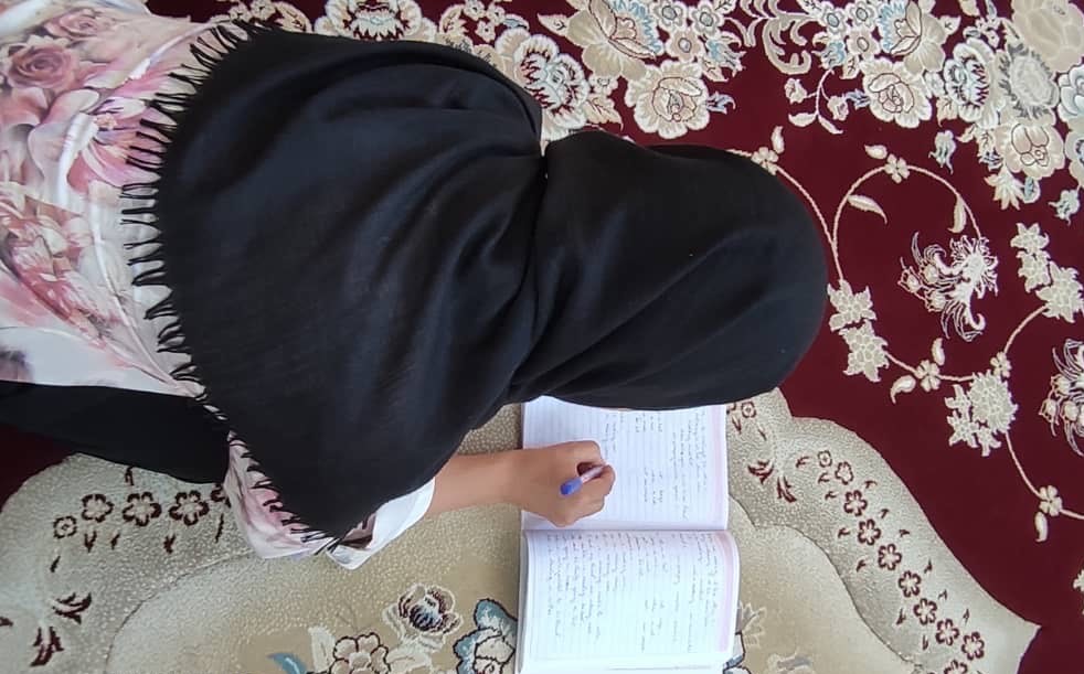 An Afghan girl, pupil of Wild Flower, doing homework