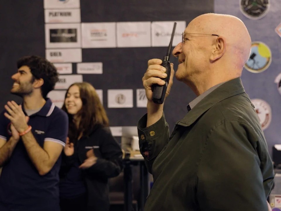 Homem de uniforme falando em rádio.