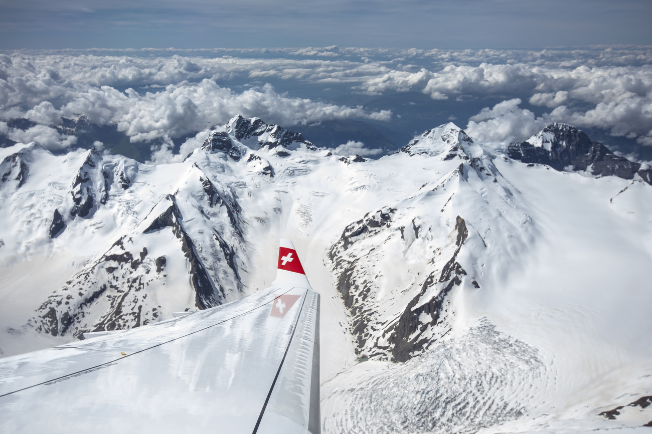 snowy mountain tops as seen from a Swiss international airline airplane woman