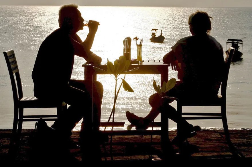 2 people drinking on a beach